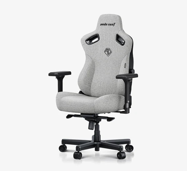 A light gray fabric gaming chair with black armrests, base, and side supports, shown on a white background with a black banner at the bottom reading 'Best Budget Big and Tall Gaming Chair by IGN'.