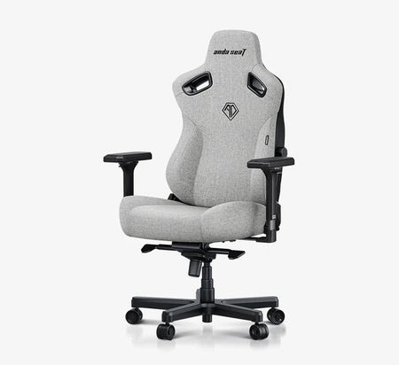 A light gray fabric gaming chair with black armrests, base, and side supports, shown on a white background with a black banner at the bottom reading 'Best Budget Big and Tall Gaming Chair by IGN'.