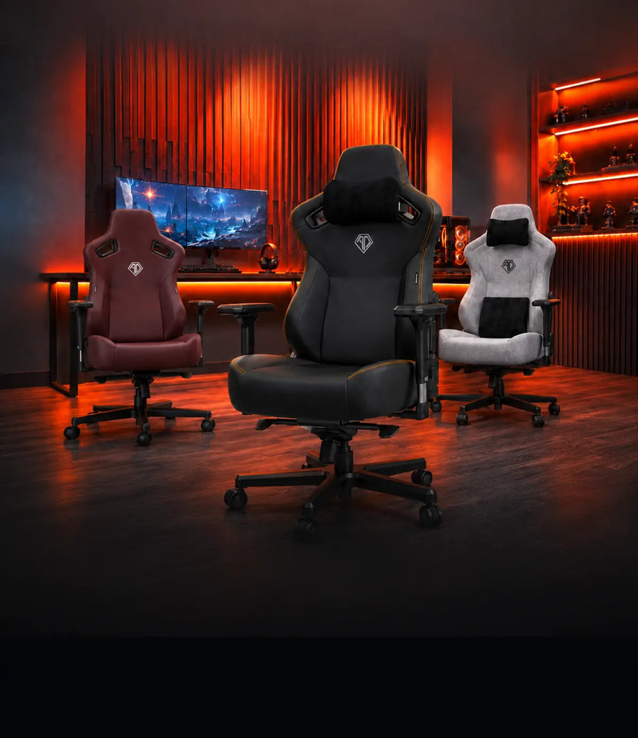 AndaSeat Novis Max XL Grey Fabric, X-Air Pro Space Black and Kaiser 4 Purple gaming chairs on a bright orange September Savings stage.